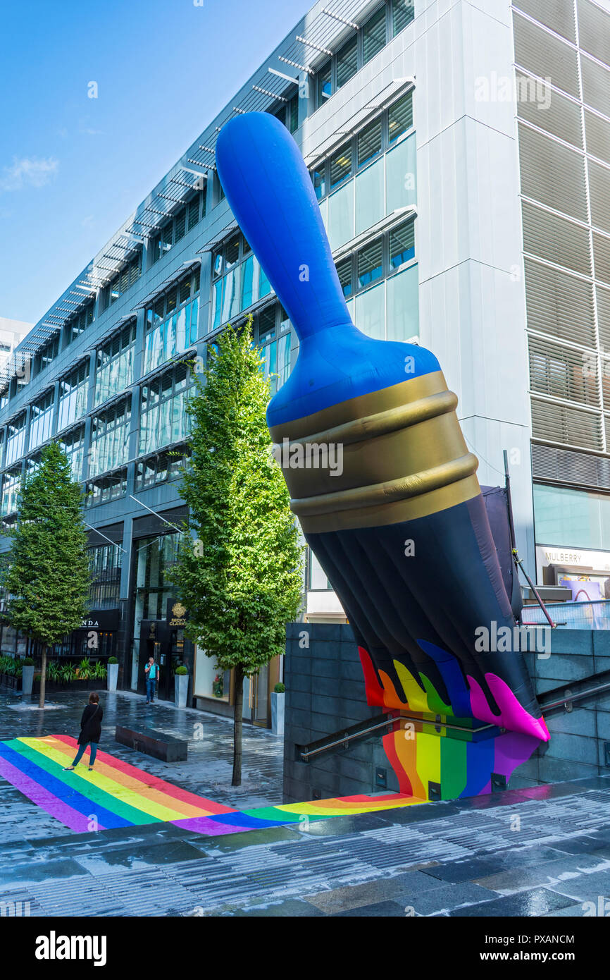 Giant inflatable paintbrush with rainbow colours, celebrating Pride festival.  At The Avenue, Spinningfields, Manchester, England, UK Stock Photo