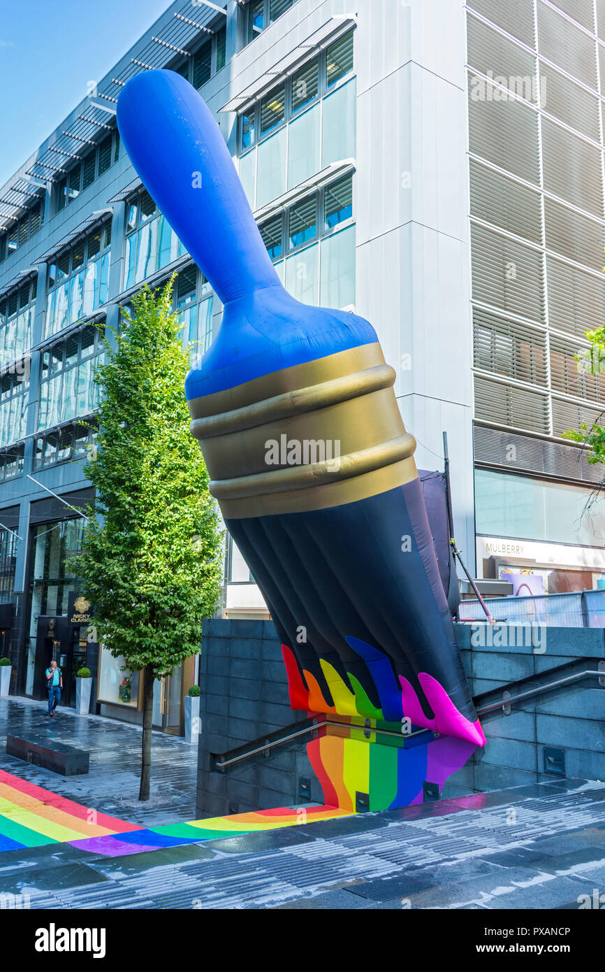 Giant inflatable paintbrush with rainbow colours, celebrating Pride festival.  At The Avenue, Spinningfields, Manchester, England, UK Stock Photo