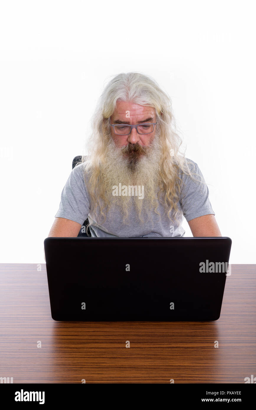 Senior bearded man wearing eyeglasses while using laptop on wood Stock Photo