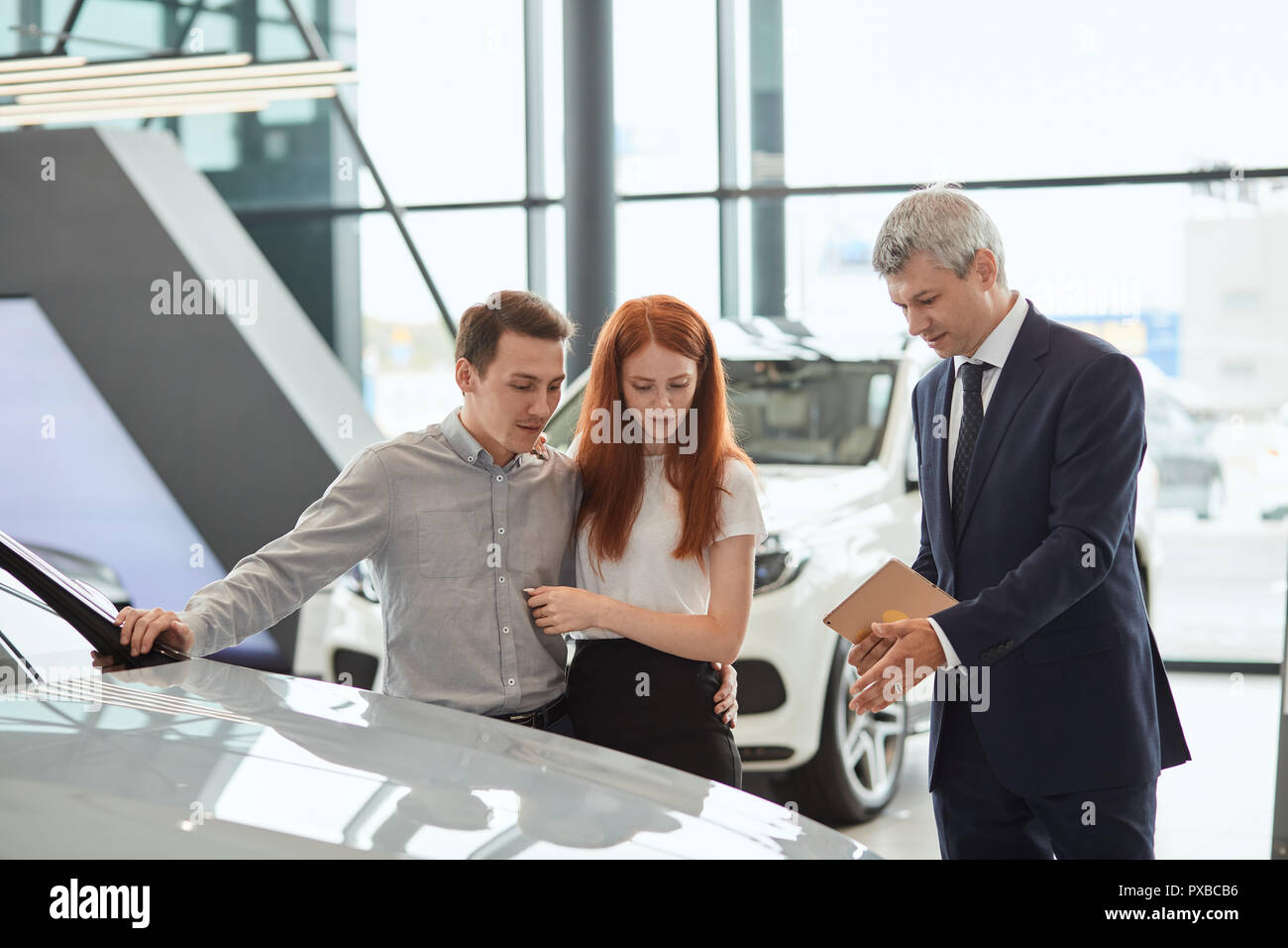 Car sales manager telling about the features of the car to the