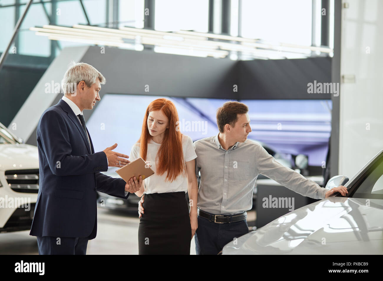 Car sales manager telling about the features of the car to the