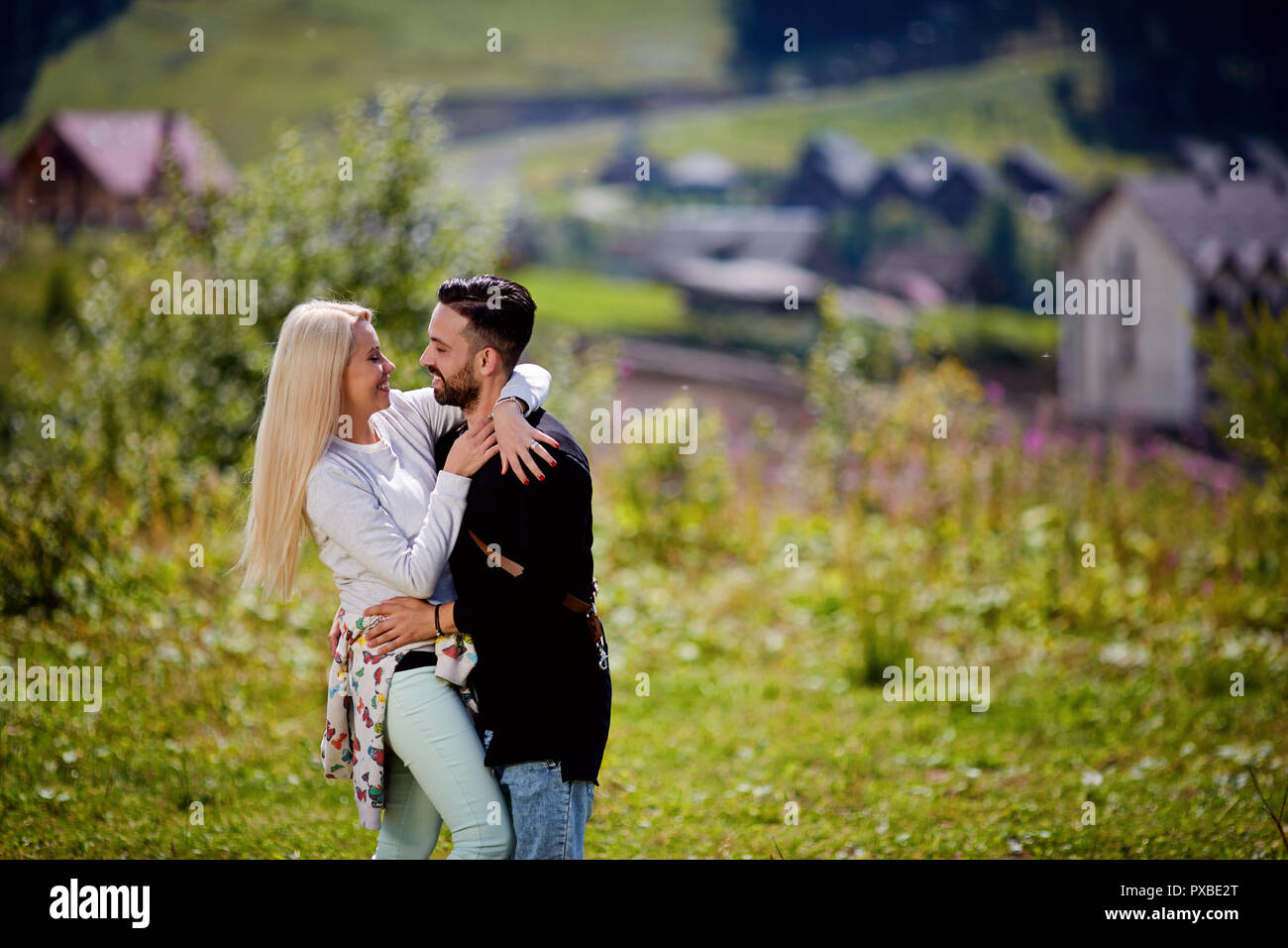 Summer holidays, people, love and dating concept - happy couple hugging over green lights background Stock Photo
