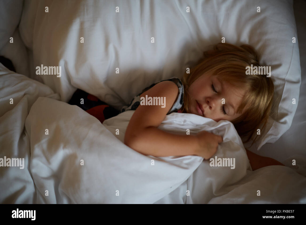 Girl lying in bed after sleeping. morning awakening, a fun morning, playing in bed Stock Photo