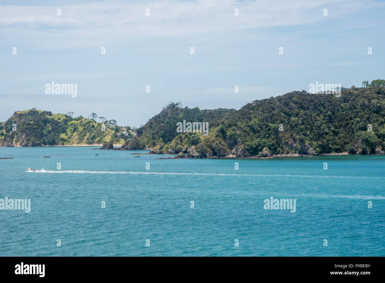 Bay of Islands, North Island, New Zealand-December 18,2016: Motorboat in the turquoise Tasman Sea with greenery in the Bay of Islands, New Zealand Stock Photo