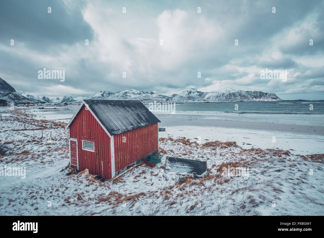 Red rorbu house shed on beach of fjord, Norway Stock Photo
