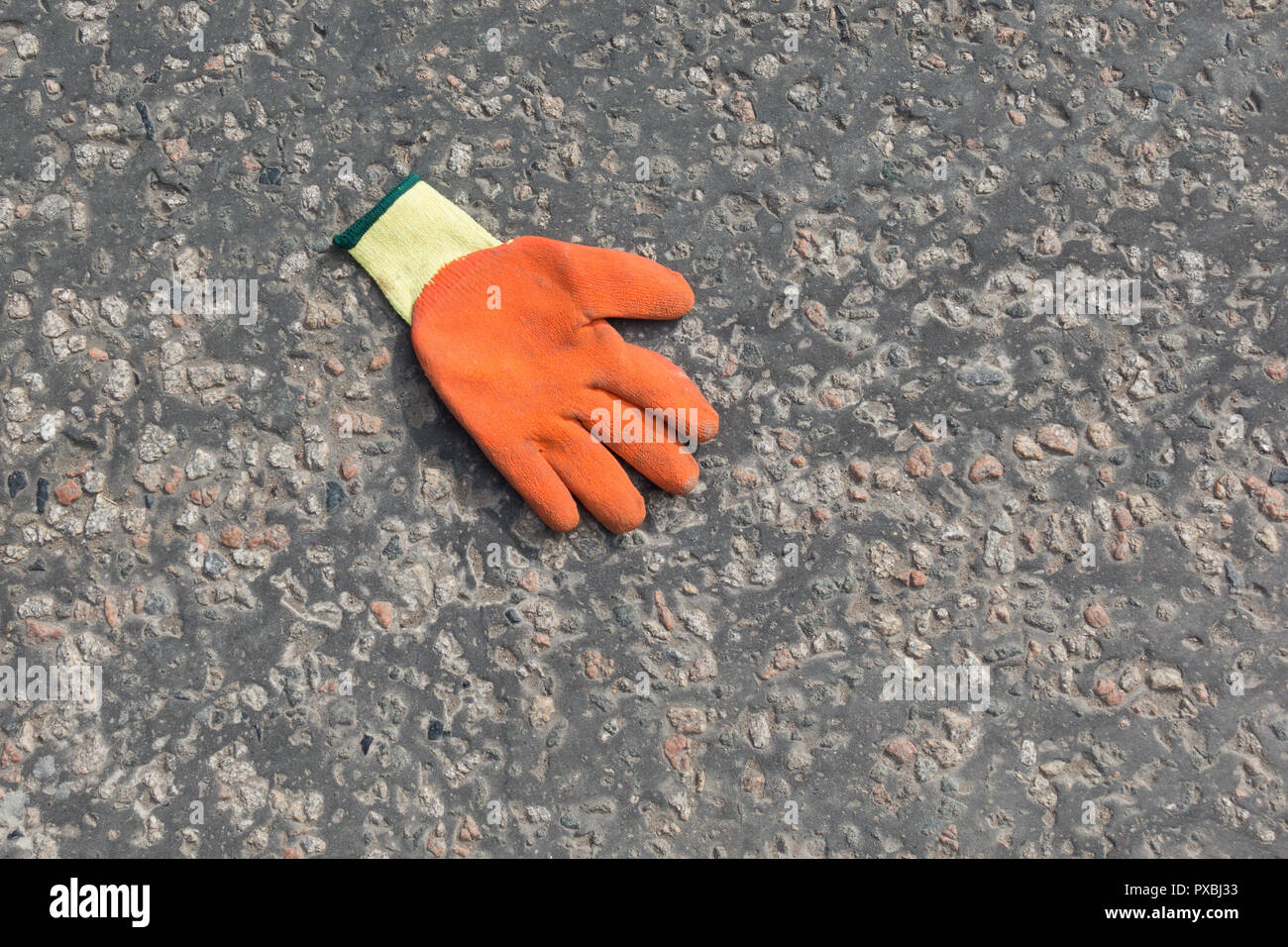 dropped workmans or workpersons glove in road - uk Stock Photo