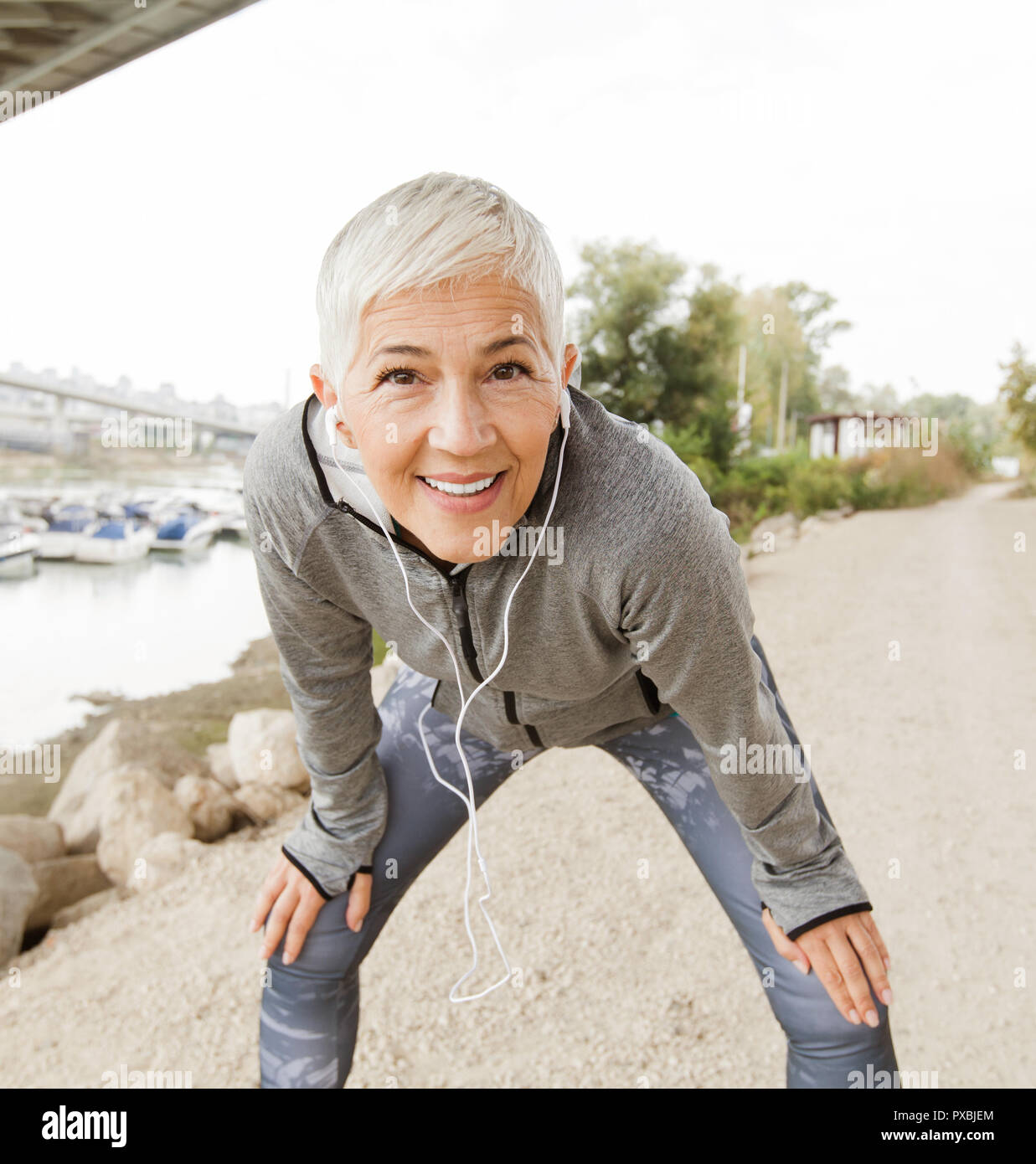Senior Woman Relax Listening Music With Earphones After Running