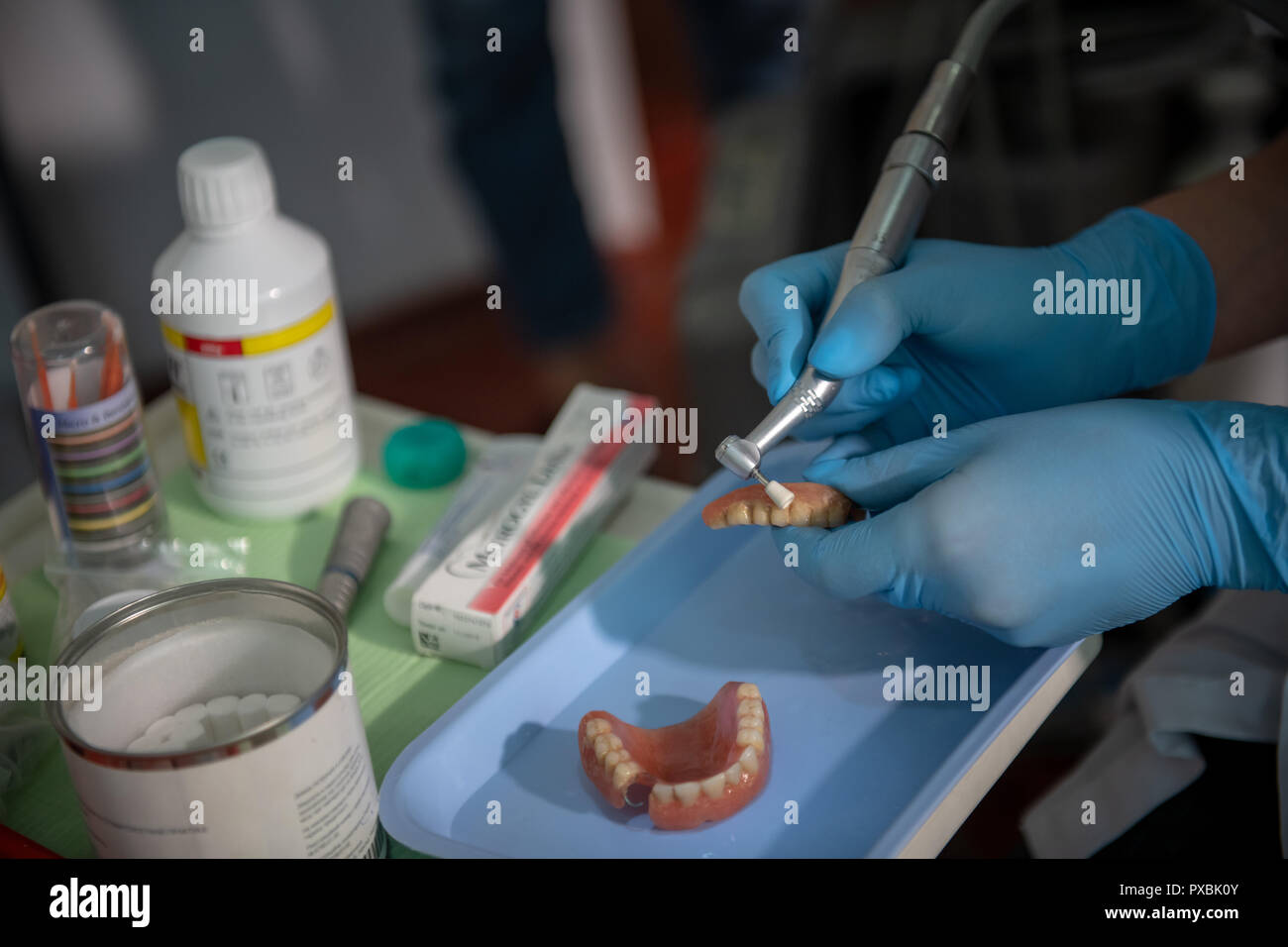 dental assistant manually cleaning old dentures by hand Stock Photo Alamy
