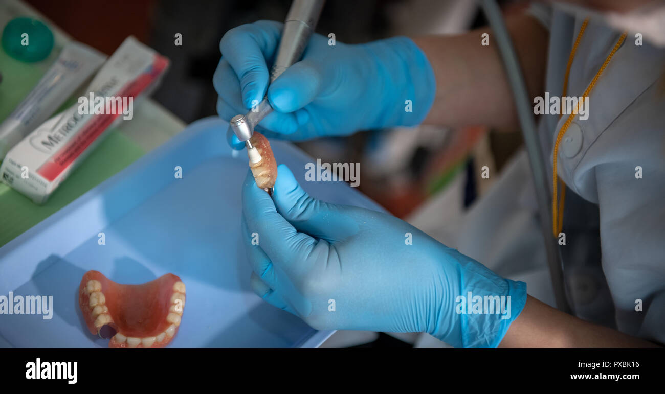 dental assistant manually cleaning old dentures by hand Stock Photo Alamy