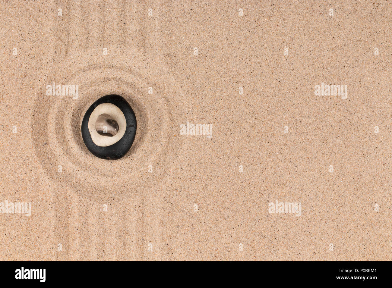 Pyramid made of stones in the center of a circle made of sand. Top view