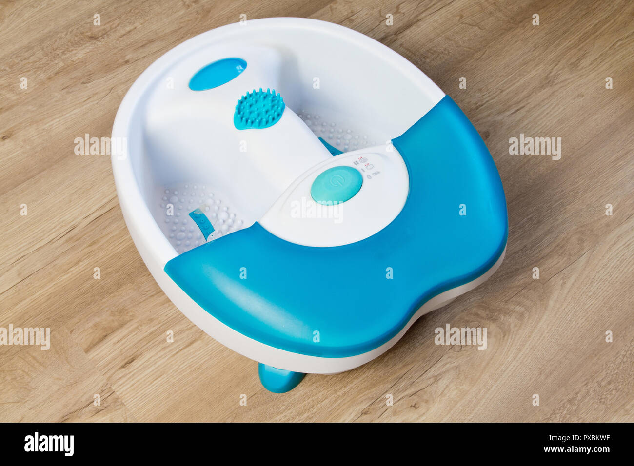 Feet in a vibrating foot massager. Electric massage bath. Foot bath