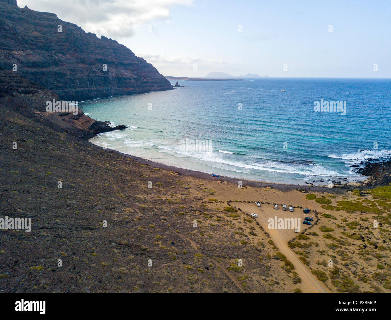 Aerial view of a crystal clear sea with waves and surfers. Playa De La Canteria. Orzola, Lanzarote, Canary Islands. Spain Stock Photo