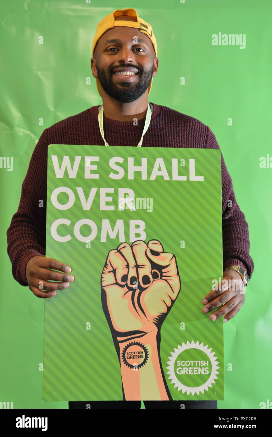 Glasgow, UK. 21st Oct 2018. WE SHALL OVER COMB. Scottish Green Party National Conference. Pictured Magid Magid - Lord Mayor of Sheffield, holding a sign of a defiant and clenched fist which reads: 'We Shall Over Comb' Credit: Colin Fisher/Alamy Live News Stock Photo