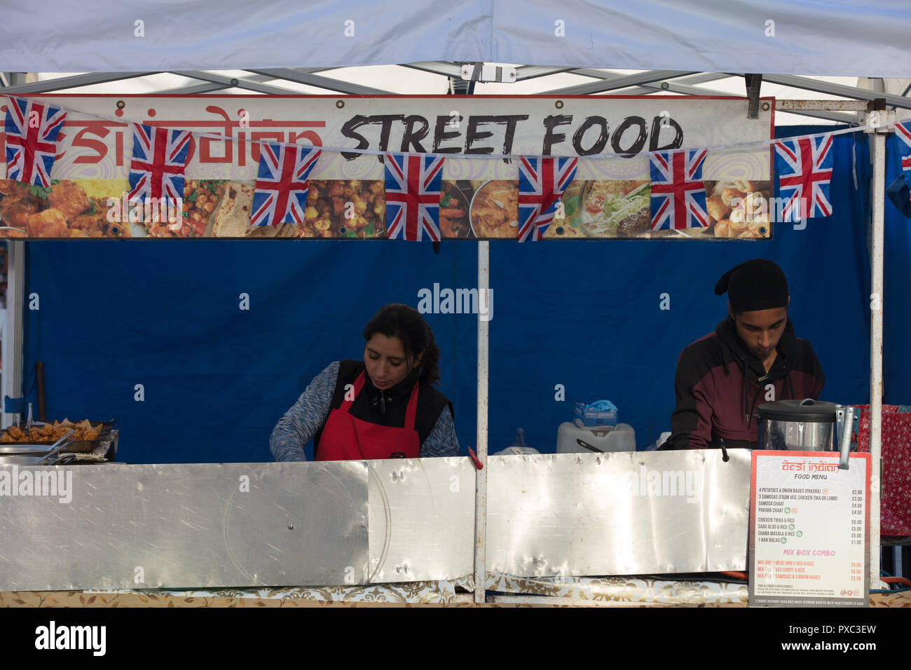 London, UK. 21st October 2018. Chefs seen preparing street food on Woolwich Market.  Credit: Joe Kuis / Alamy Live News Stock Photo