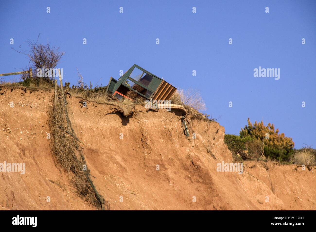 Sidmouth, UK. 21st Oct 2018.  Going, going - almost gone. Coastal erosion claims another victim as the 'Shed of Sidmouth' collapses at the cliff edge. The now infamous shed almost disappeared in April this year, after which the owner added a 'For Sale' sign to the perilous structure. A local pub has been running a book on how long the shed would survive. Photo Central/Alamy Live News Stock Photo