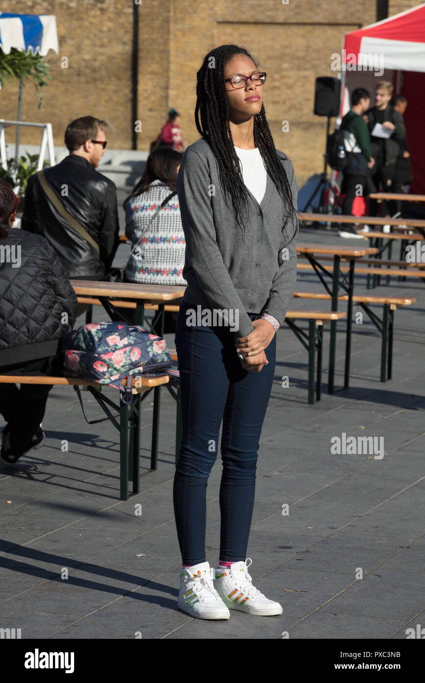 Woolwich, London, UK. 21st October 2018. Woman seen enjoying the autumn sun onWoolwich Market.  Credit: Joe Kuis / Alamy Live News Stock Photo