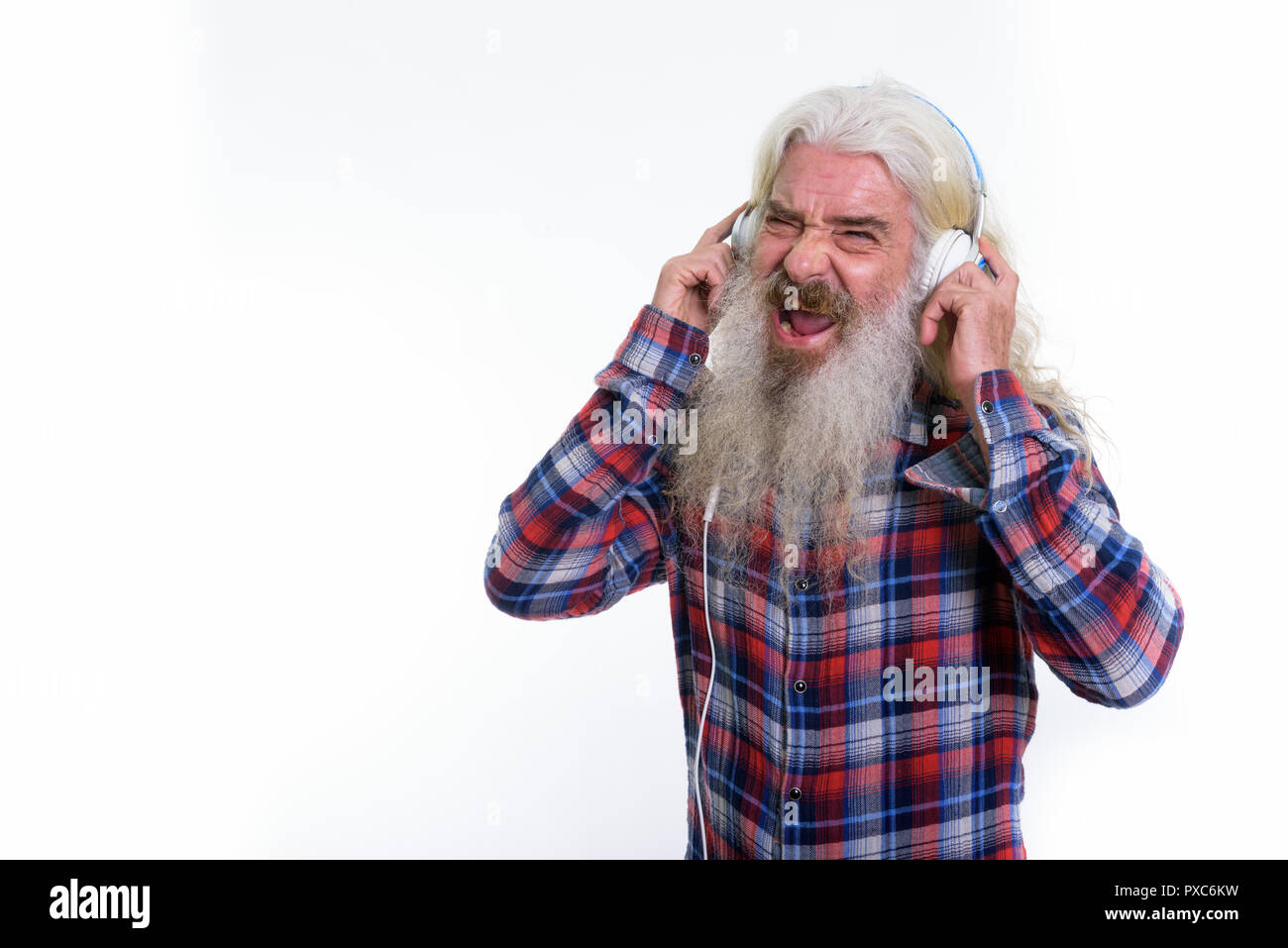 Studio shot of happy senior bearded man smiling and singing whil Stock Photo