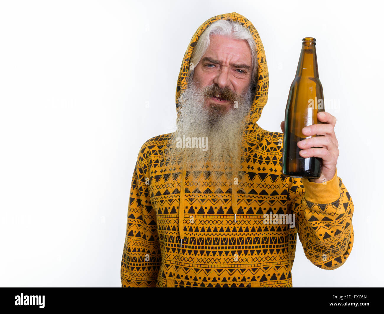 Studio shot of drunk senior bearded man wearing hoodie while hol Stock Photo