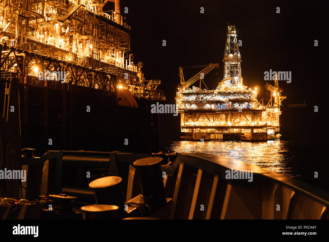 FPSO tanker vessel near Oil platform Rig at night. Offshore oil and gas industry Stock Photo
