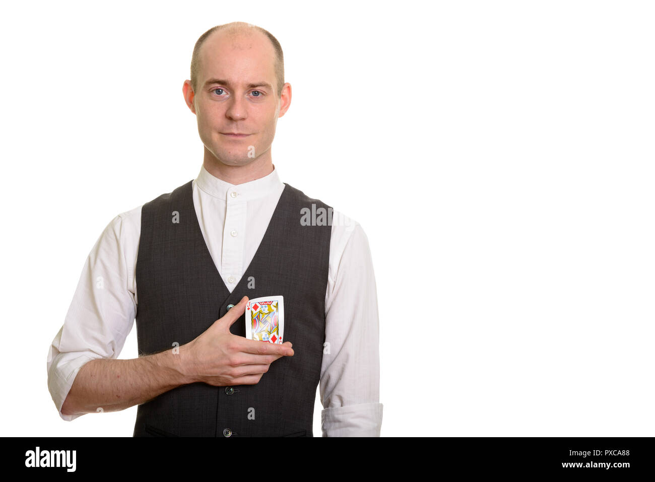Bald Caucasian magician man bending Jack of Diamonds card Stock Photo