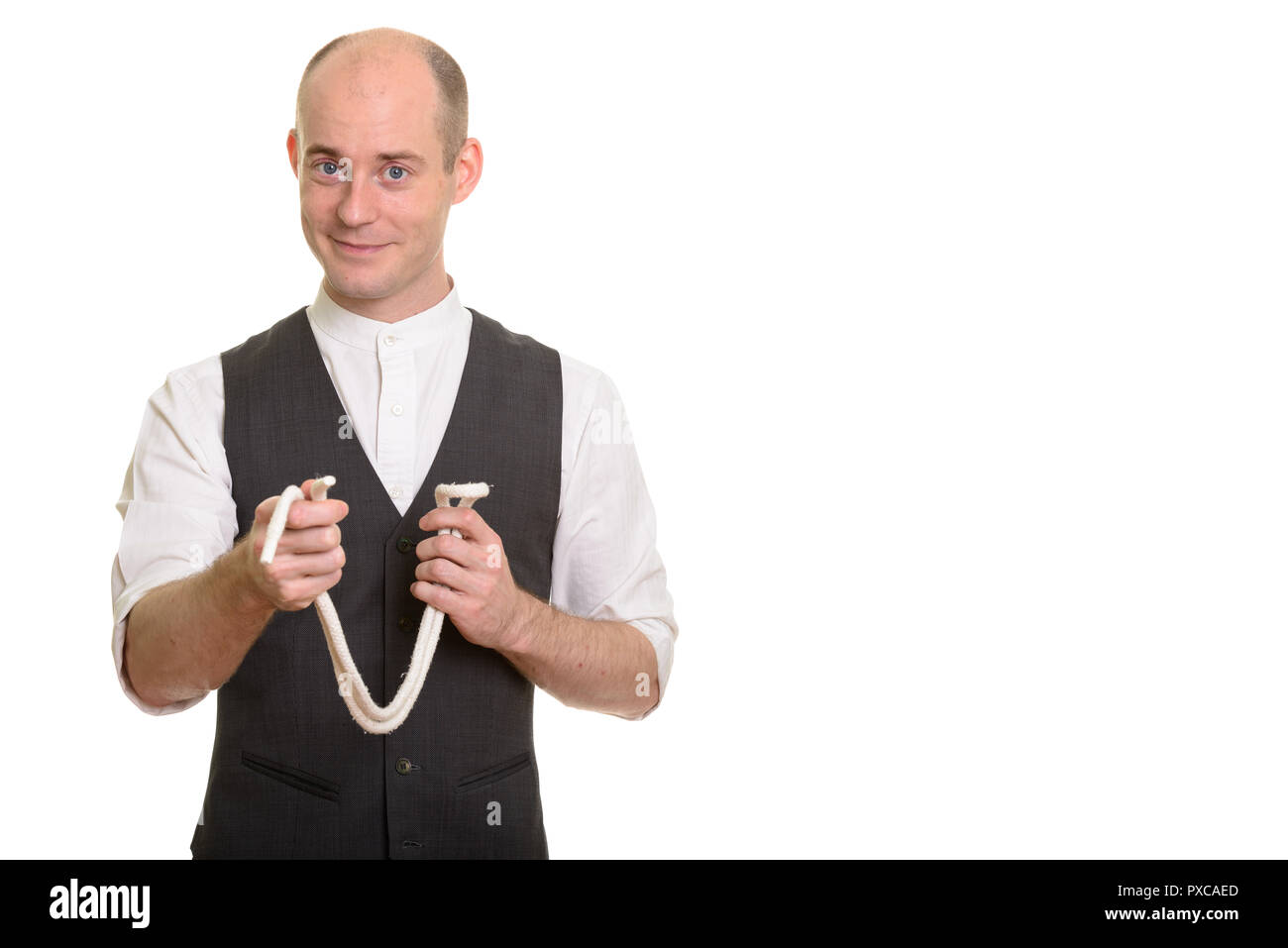 Bald Caucasian magician man holding rope for magic trick Stock Photo