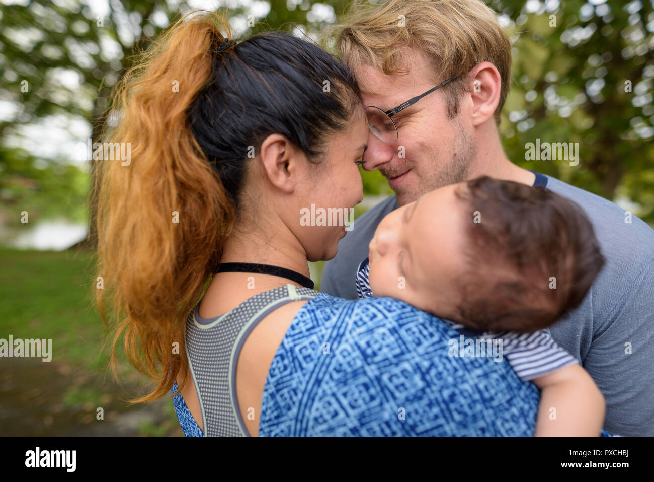 Multi-ethnic young family bonding together at the park Stock Photo