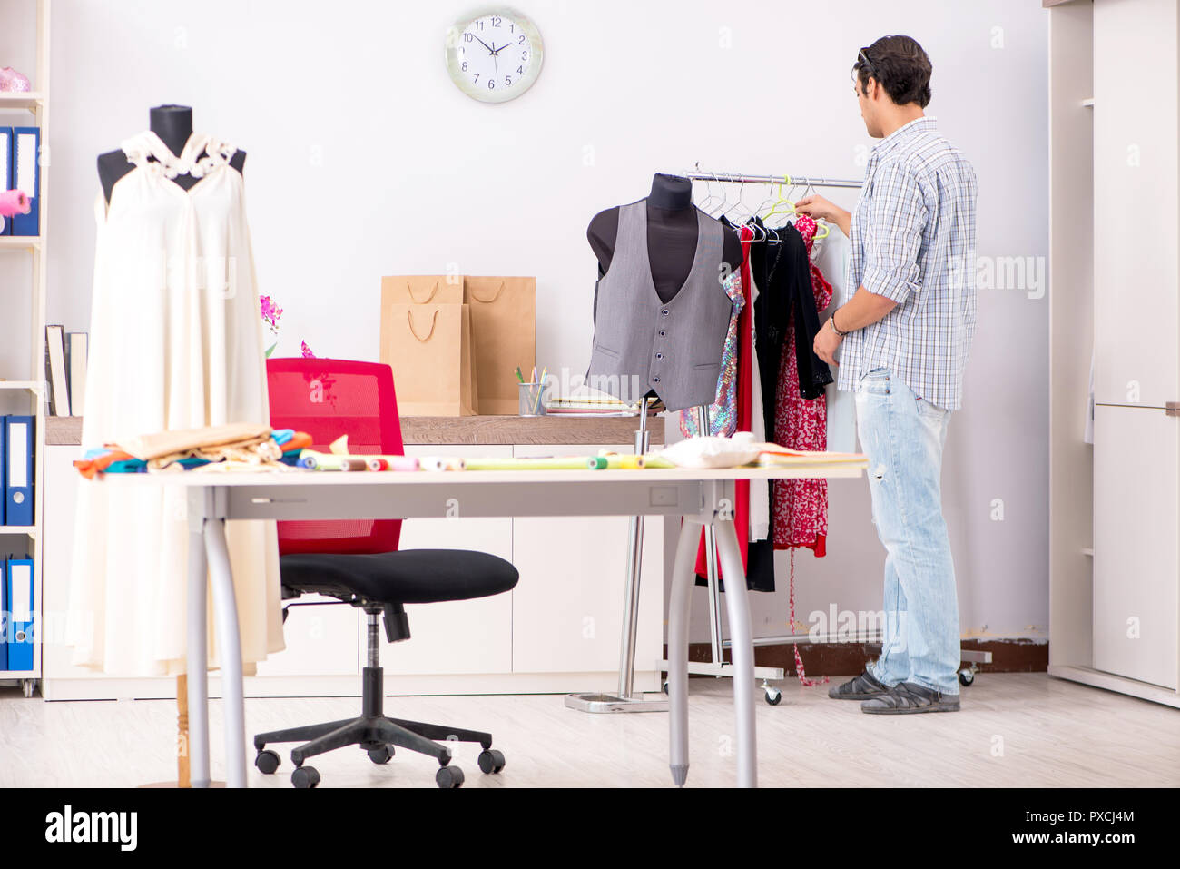 Young handsome tailor working in his workshop Stock Photo - Alamy