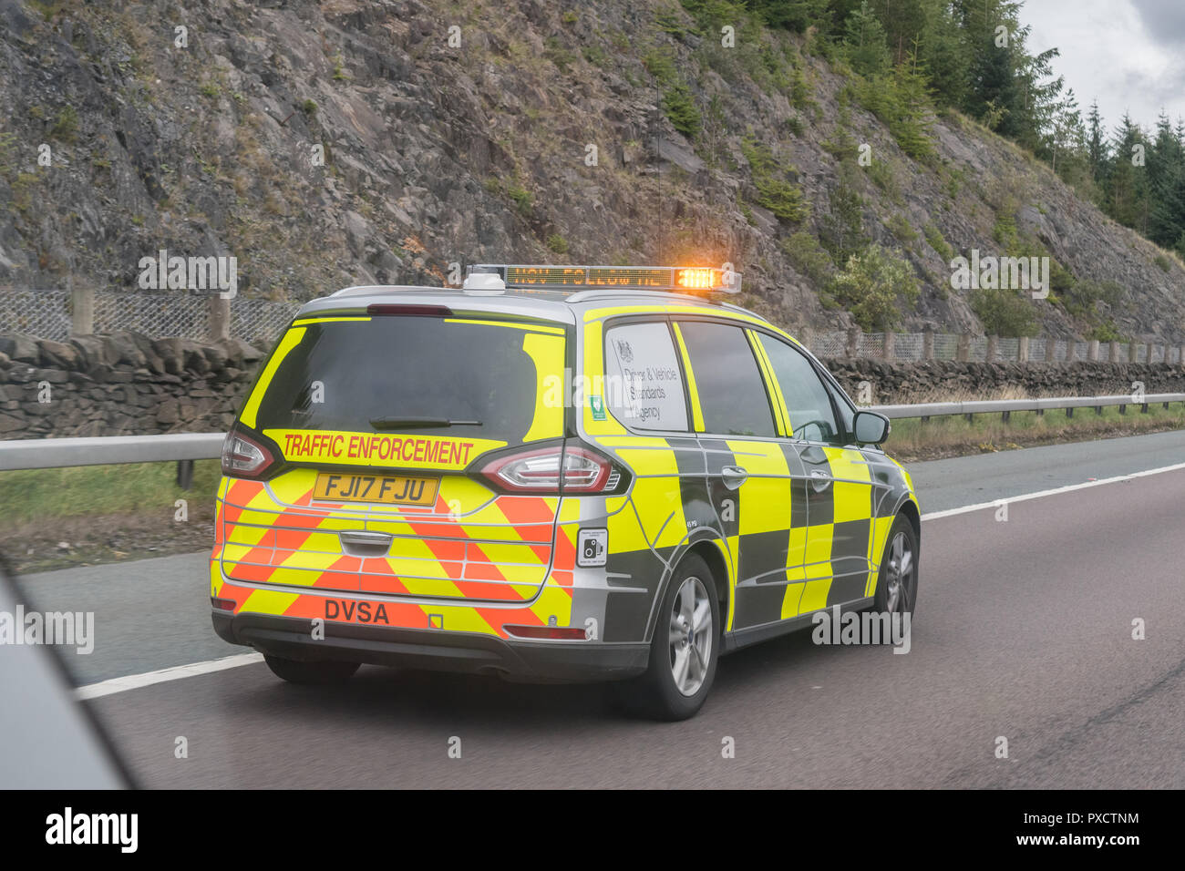 Traffic enforcement vehicle on A74(M) by Beattock Check Site asking an HGV driver to pull over using matrix message sign displayed on light bar Stock Photo