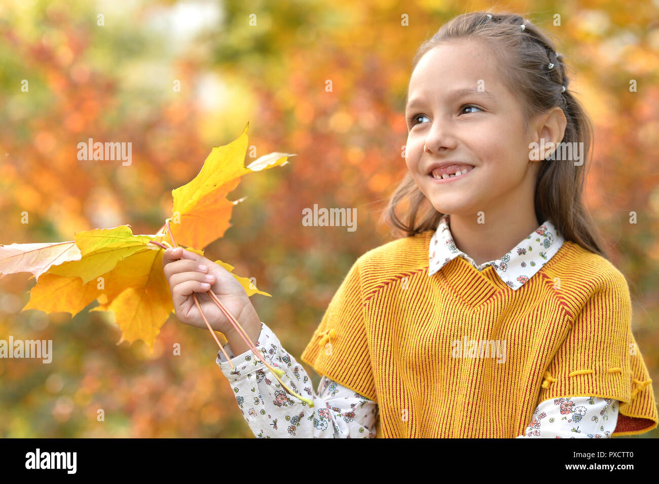 Portrait of a cute little girl smiling in autumnal park Stock Photo - Alamy