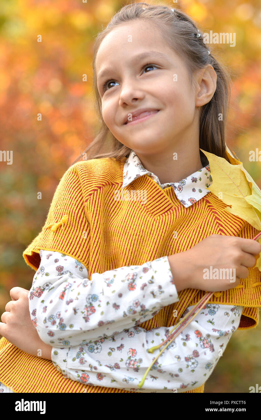 Portrait of a cute little girl smiling in autumnal park Stock Photo - Alamy