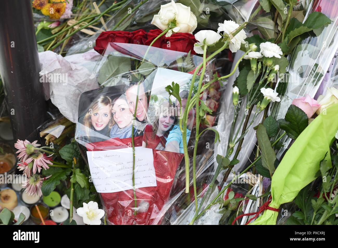 November 22, 2015 - Paris, France: People pay tribute to the victims of the November 13 terror attacks with candles, drawings, street arts, and pictures of the dead with impromptu memorial near the Carillon bar and the Petit Cambodge restaurant. Des photos des victimes des attaques terroristes du 13 novembre 2015 sont posees au milieu de fleurs le long d'un memorial improvise pres du bar Le Carillon. *** FRANCE OUT / NO SALES TO FRENCH MEDIA *** Stock Photo