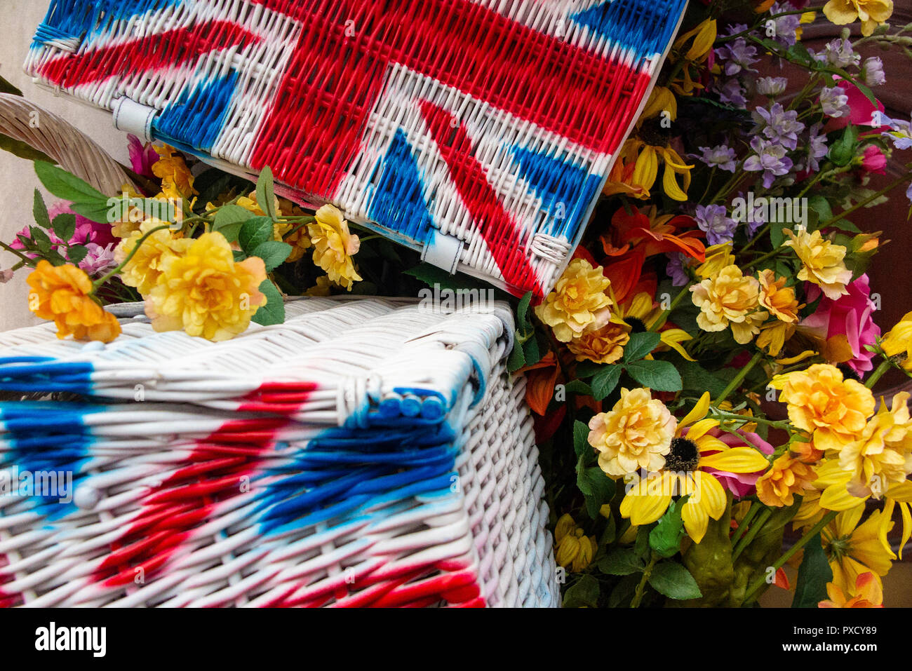 Union flag hampers amongst brightly coloured flowers in the summer Stock Photo