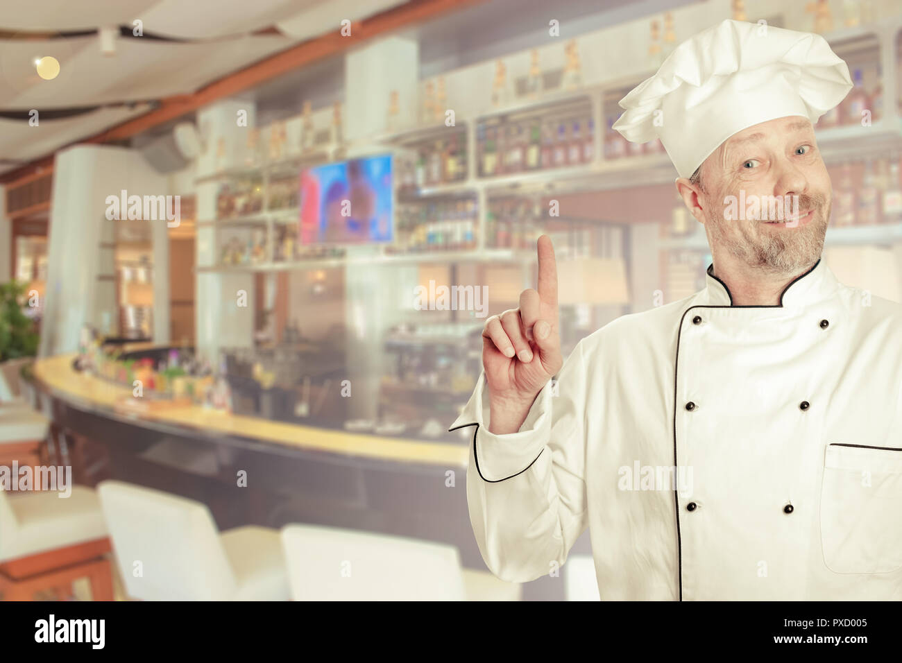 The chef is a white man in uniform with a bar counter. Stock Photo