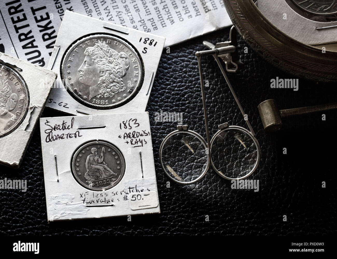 Coin Collecting - Various Coins - Morgan Dollars - Seated Liberty - against backdrop of the Greysheet with magnifiers Stock Photo