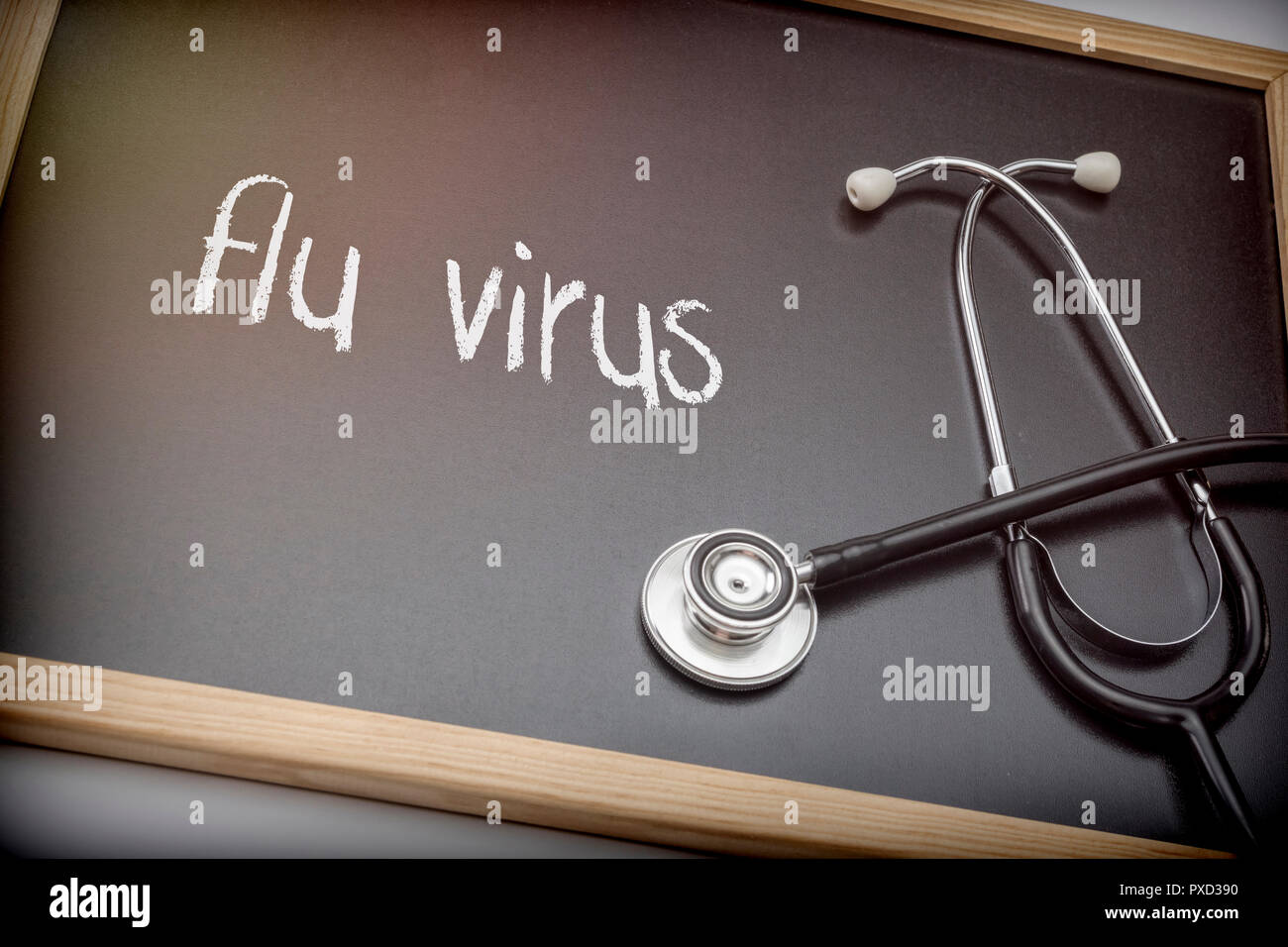 Word flu viris written in chalk on a blackboard black next to a stethoscope, conceptual image Stock Photo