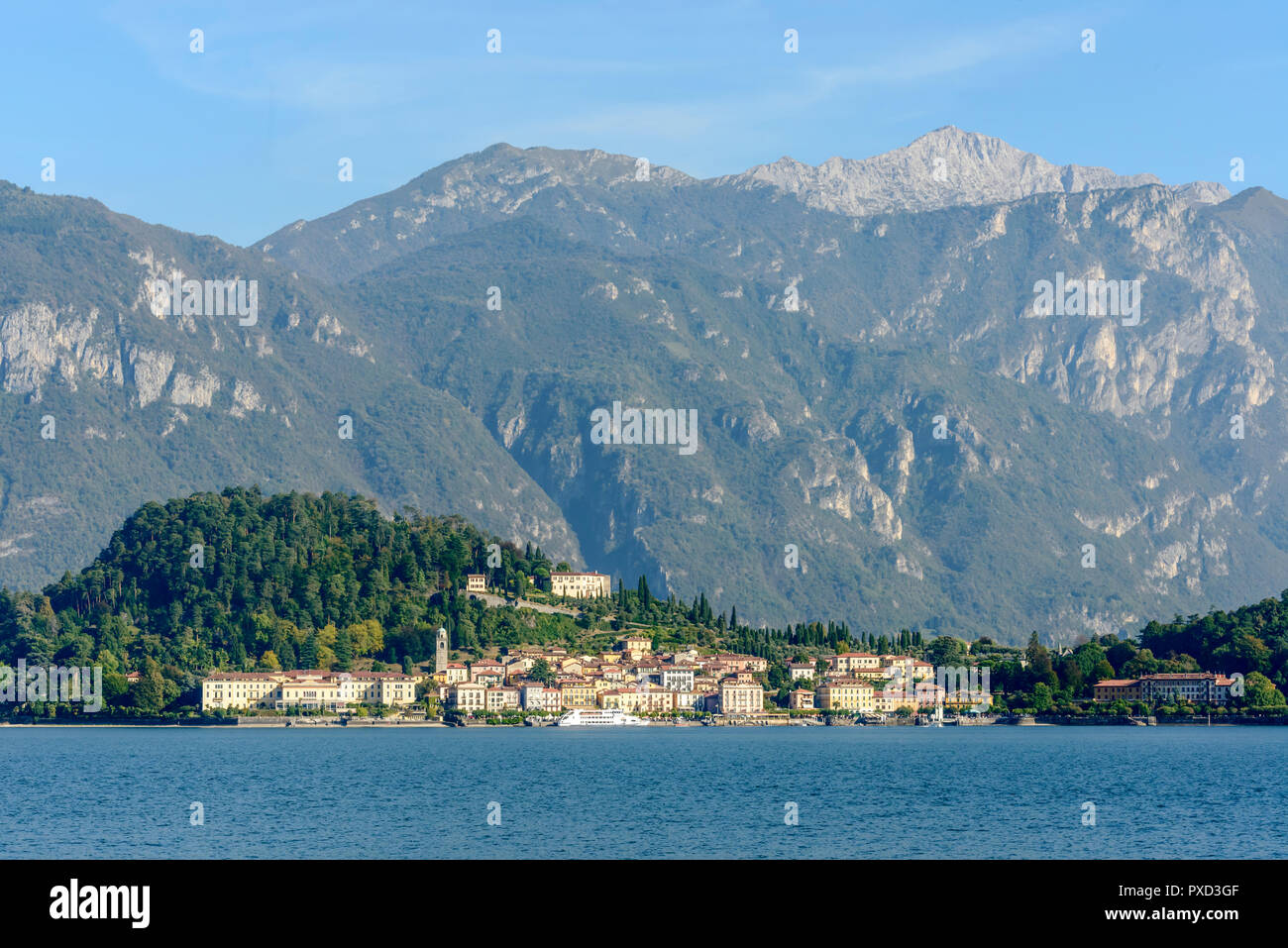landscape of green lake coast of Como lake with Bellagio village, looming in background the Grigna peak range, shot in bright fall light from Cadenabb Stock Photo
