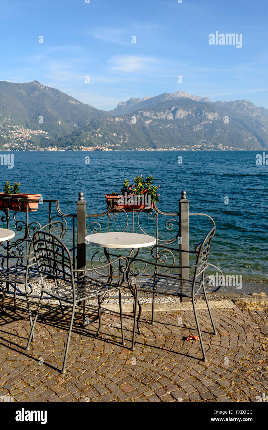 wrought iron chairs and table on lake side of Como lake , shot in bright fall light at Menaggio, Como, Italy Stock Photo