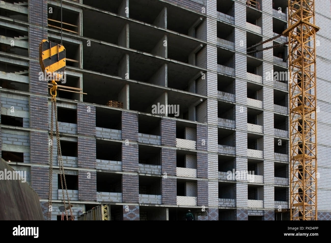 Largescale construction of a modern building with a crane in the foreground, floors and walls