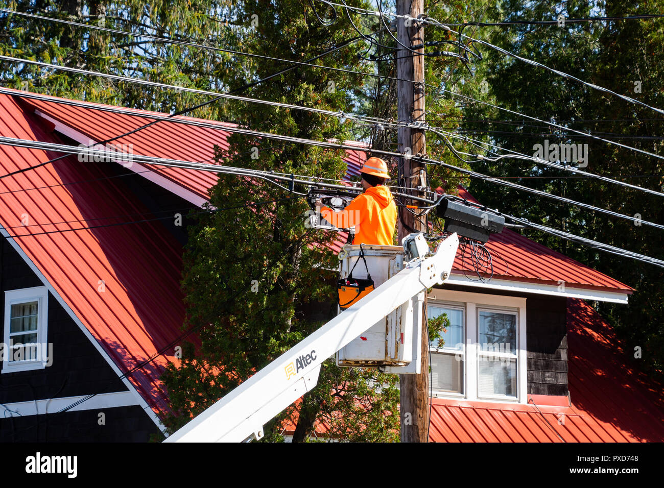 A worker in a aerial work platform connecting fiber-optic cables for new high speed internet connections. Stock Photo