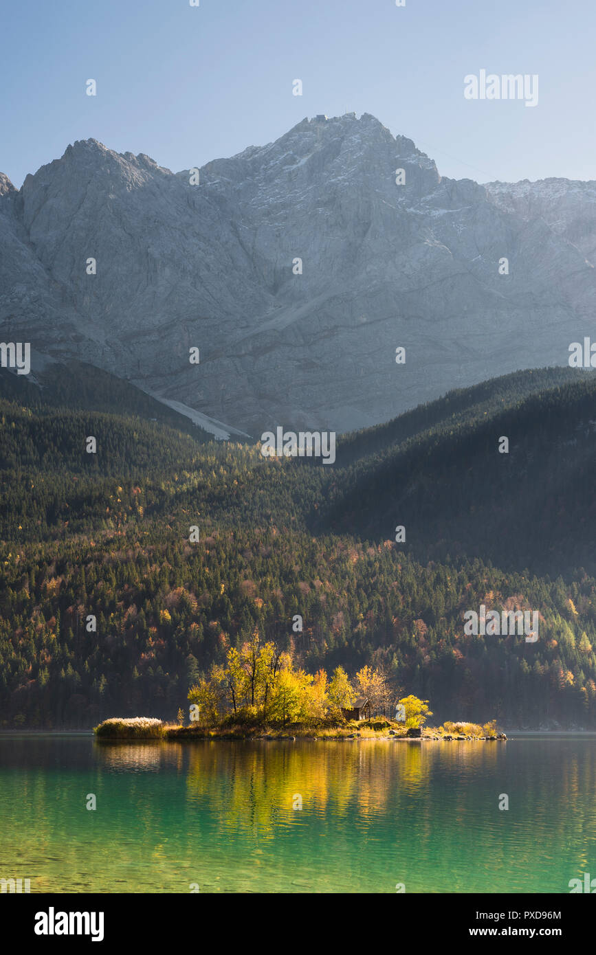 Maximilian Island in the LakeEibsee in front of the rock wall and summit of the Zugspitze in the Wetterstein Mountains in autumn, Bavaria, Germany Stock Photo