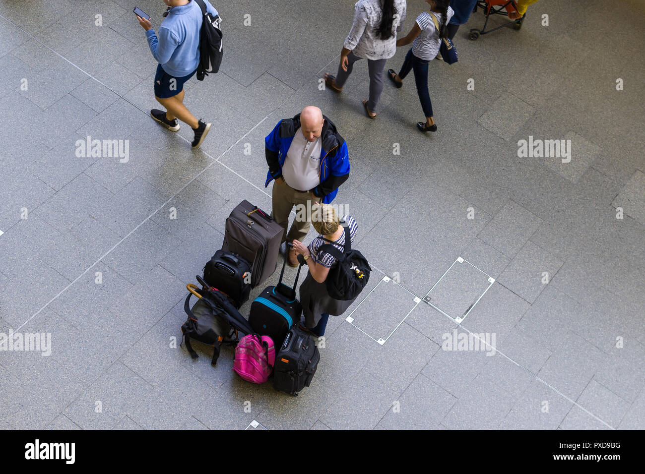 Commuters stand talking with suitcases in St Pancras International, London, UK Stock Photo