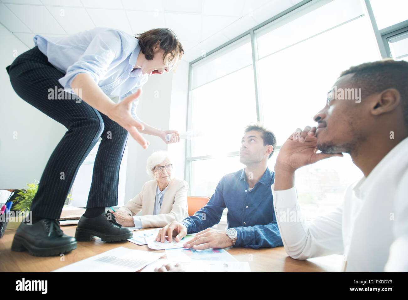 Crazy female manager screaming at colleagues Stock Photo