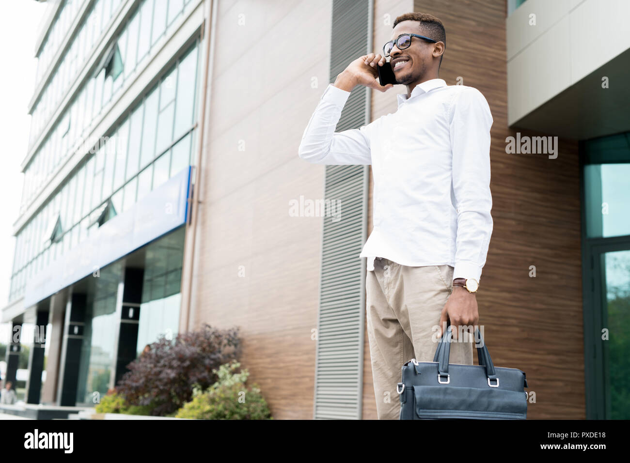 Smiling confident manager talking to client on phone Stock Photo