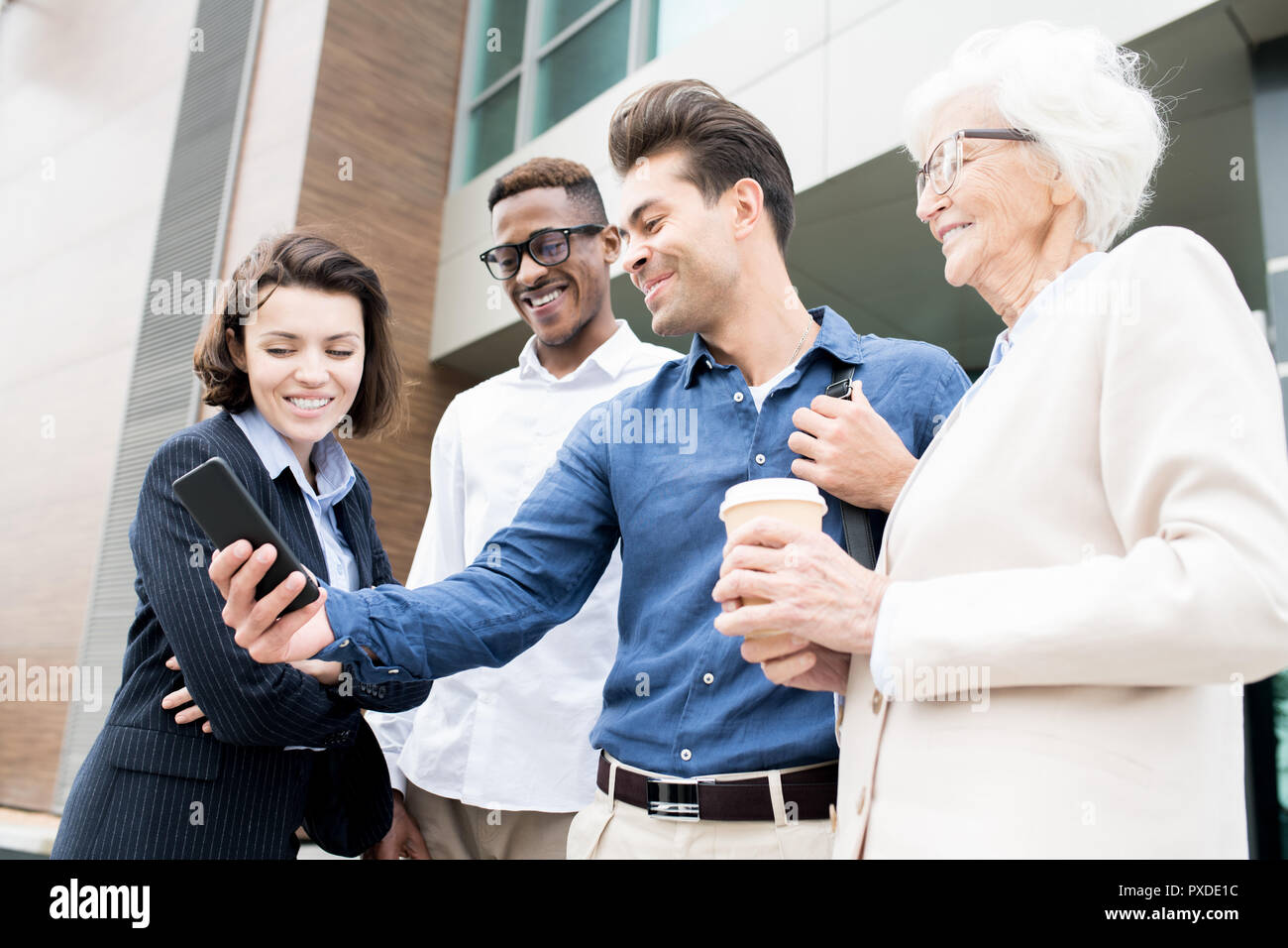 Cheerful colleagues using convenient mobile app for business Stock Photo