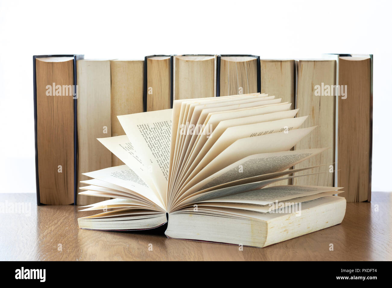 Row of old books open book at the front. Stock Photo