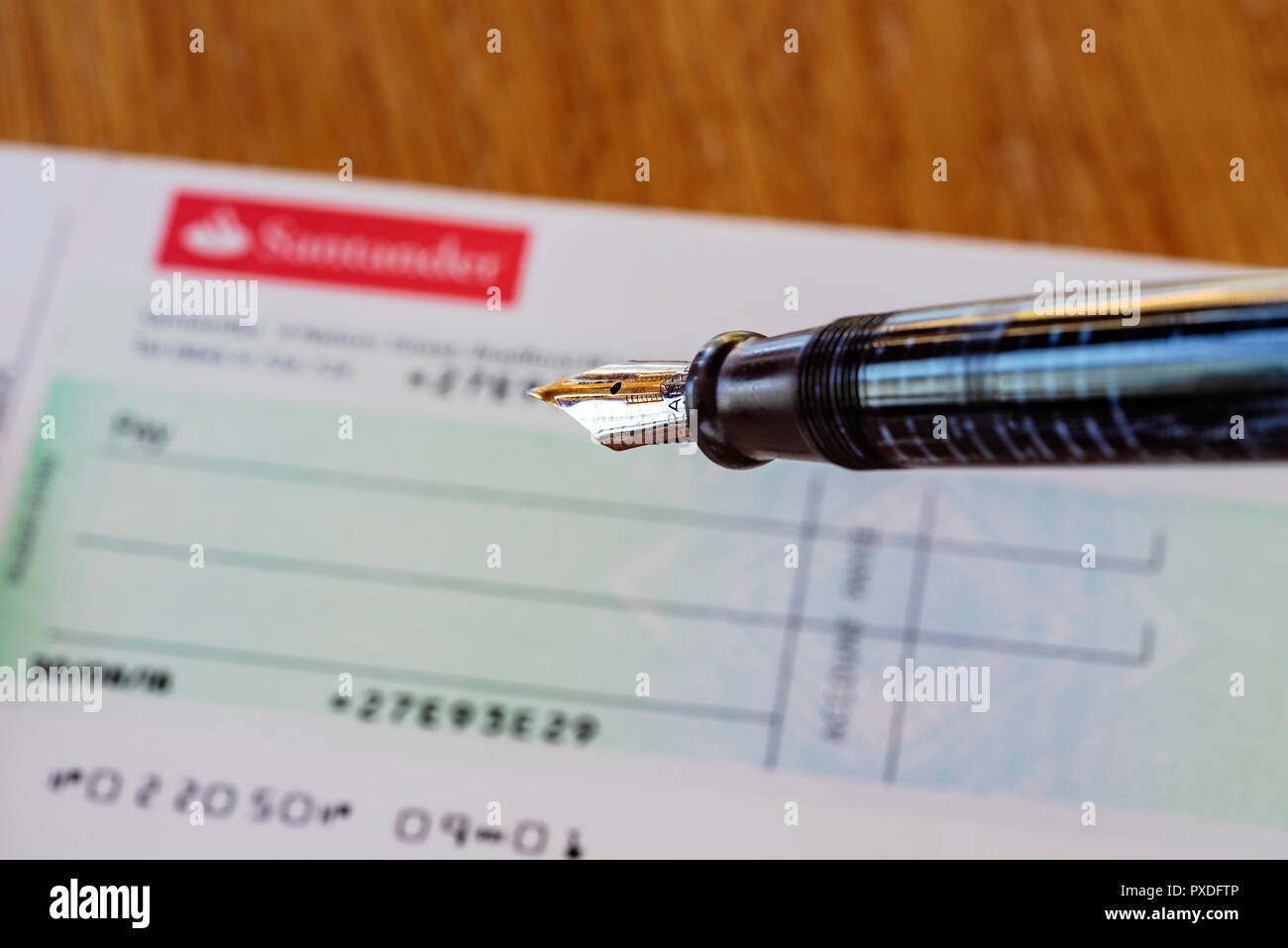 Santander cheque book and fountain pen. Retro or old school banking. Writing a check. Stock Photo