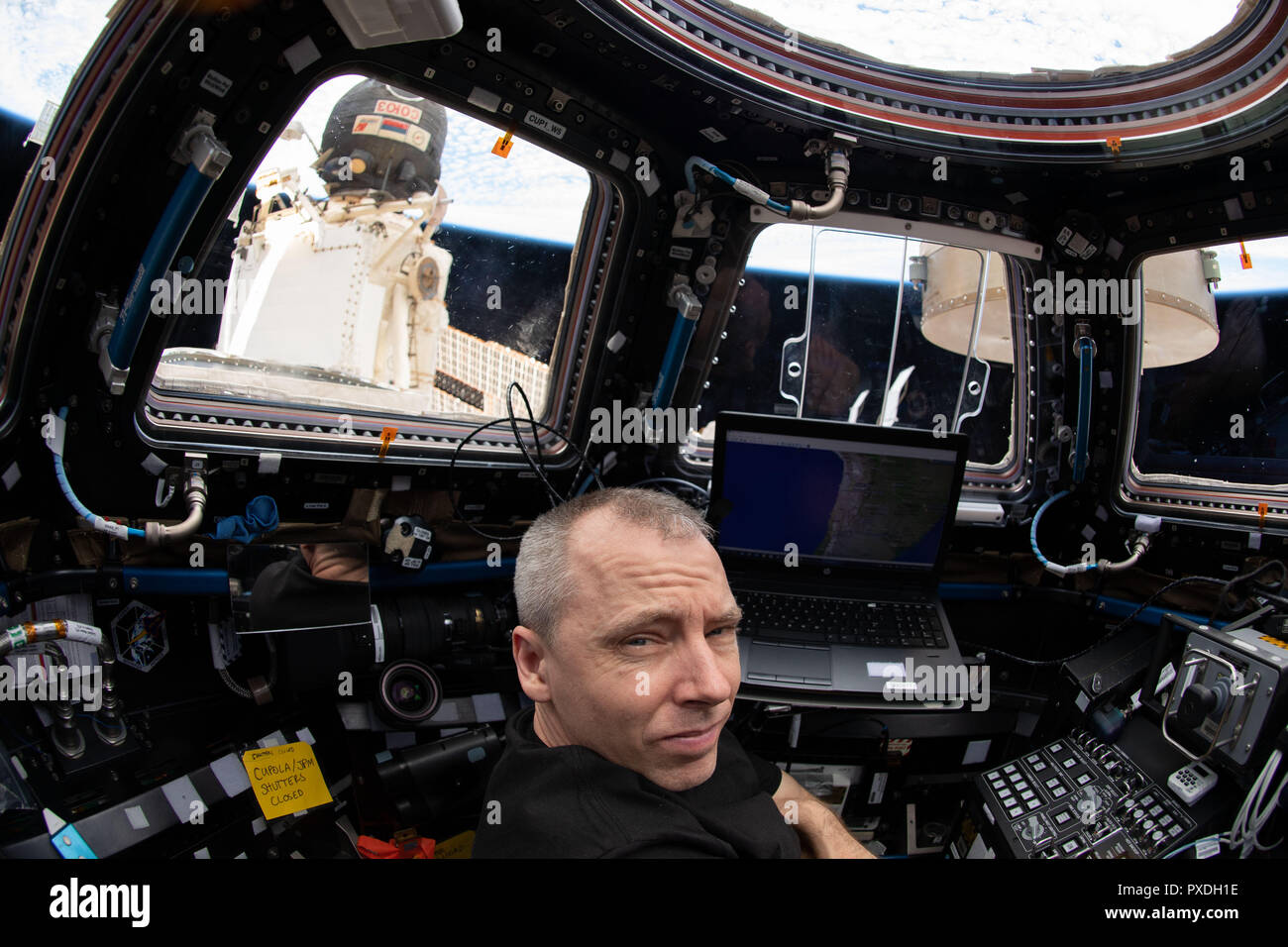 Expedition 56 Commander Drew Feustel of NASA works inside the seven-windowed Cupola as the International Space Station was about to fly over the coast of Chile in South America September 6, 2018 in Earth Orbit. Just outside the Cupola and docked to the Rassvet module is the Soyuz MS-09 spacecraft. Stock Photo