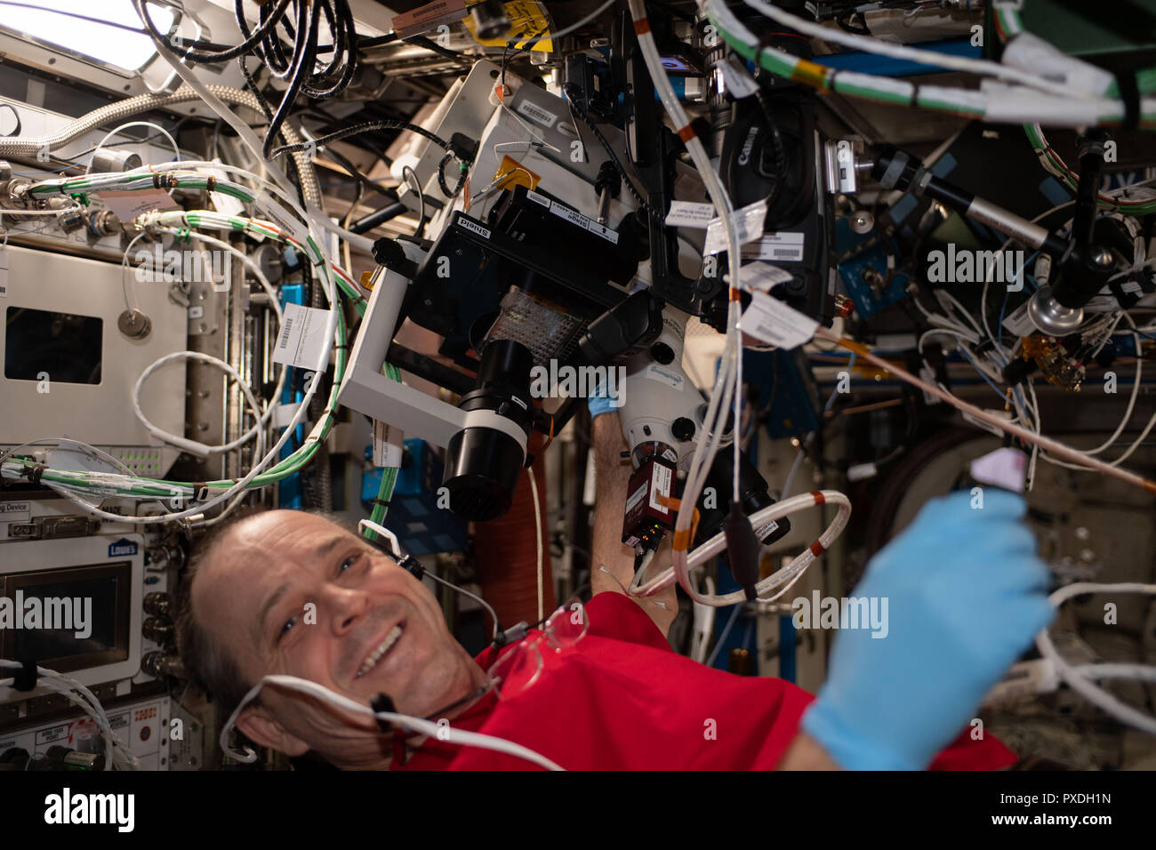 NASA Astronaut Ricky Arnold performs microscope photo document operations for the Protein Crystal Growth-13 experiment aboard the International Space Station August 31, 2018 in Earth Orbit. The PCG13 investigation seeks to enhance the way crystals are grown in a microgravity environment by allowing crew members to observe imperfections within a crystal and make real-time adjustments to follow-up experiments, rather than returning a sample to Earth and relaunching to try again. Stock Photo