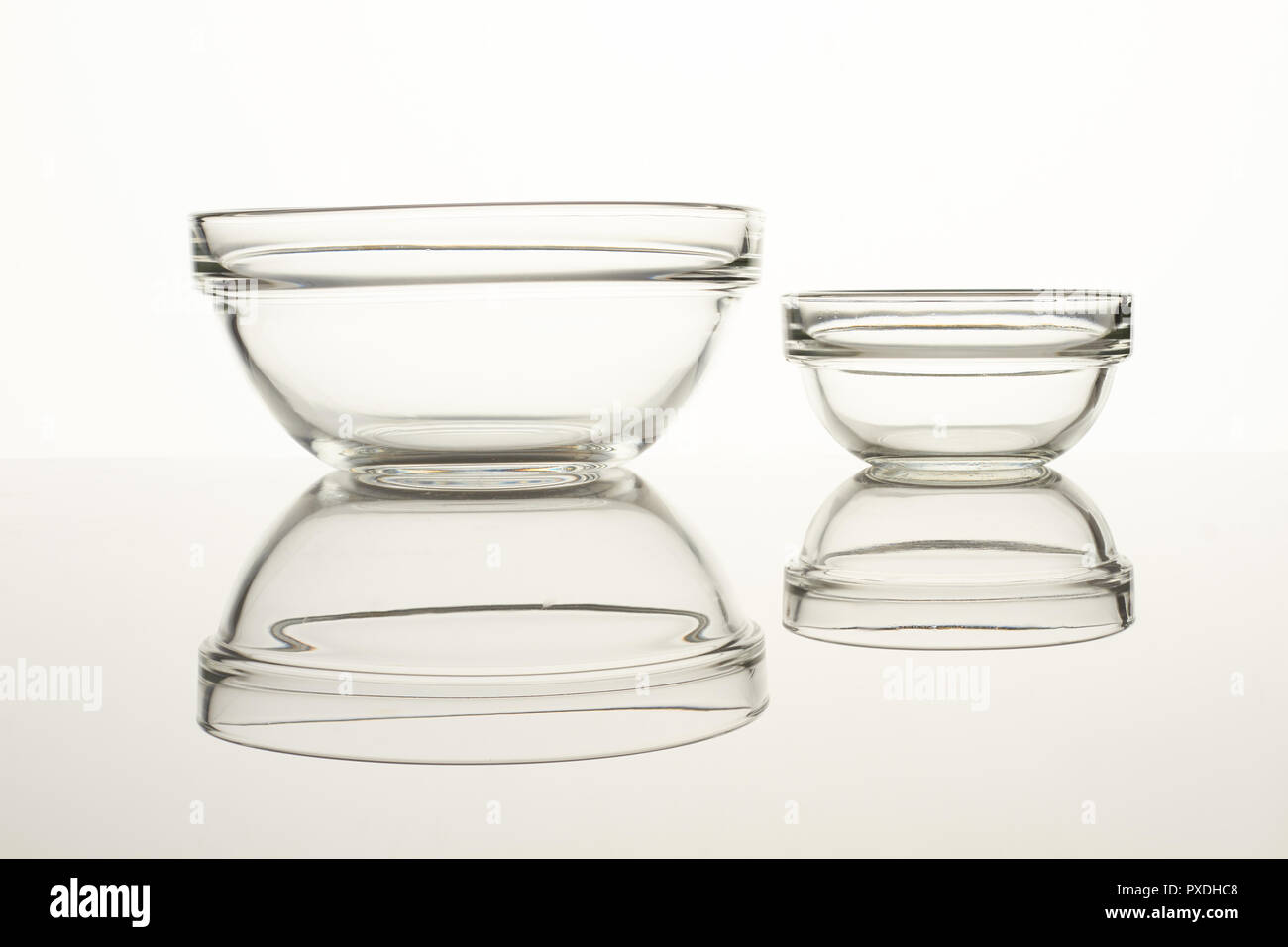Two glass bowls on reflective surface Stock Photo Alamy