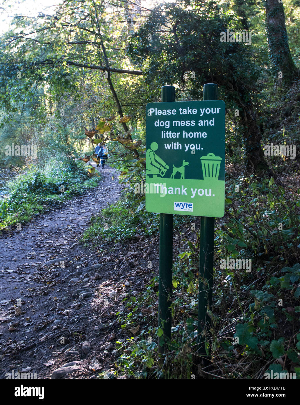 Polite notice notice to take dog mess and litter home from Brock Valley Nature walk with people on path . Brock Mill Preston Lancashire England UK Stock Photo